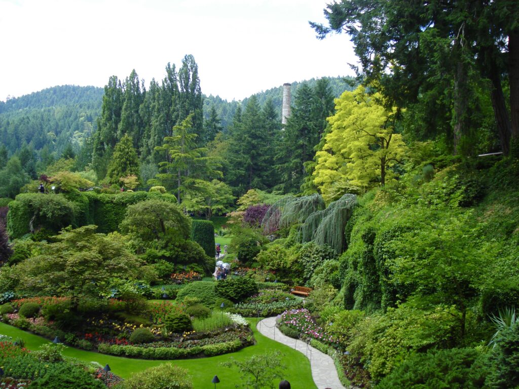 Sunken Garden at Butchart Gardens with historic cement plant chimney in the background