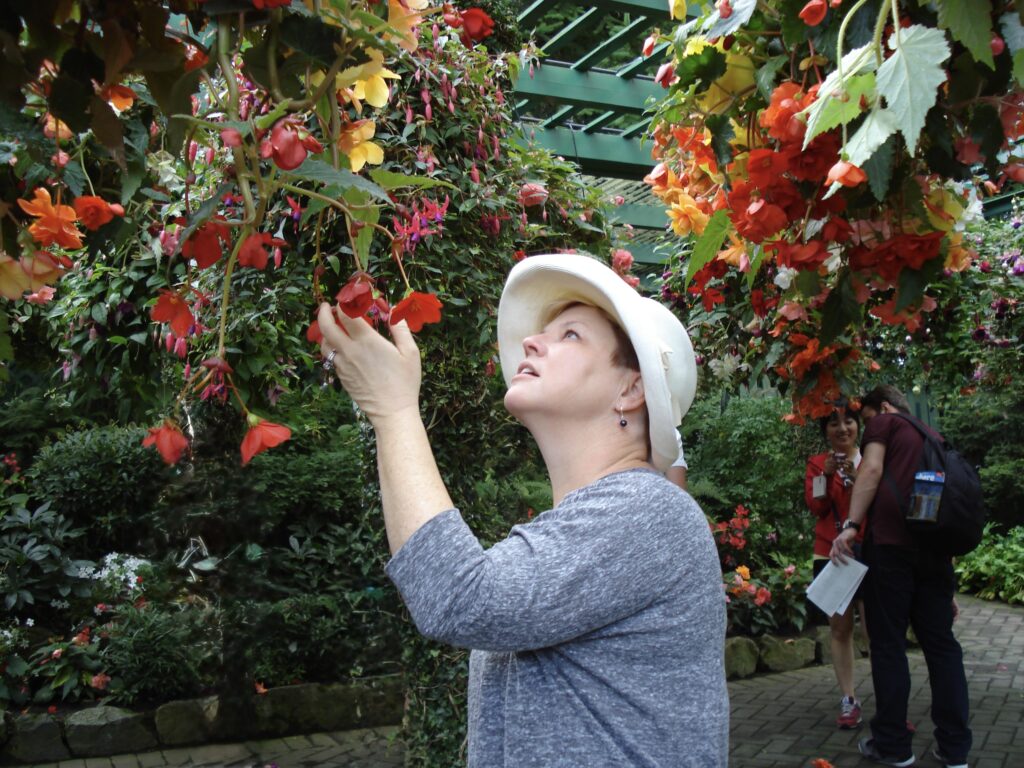Visitor admiring vibrant hanging flowers at The Butchart Gardens in Victoria BC during spring

