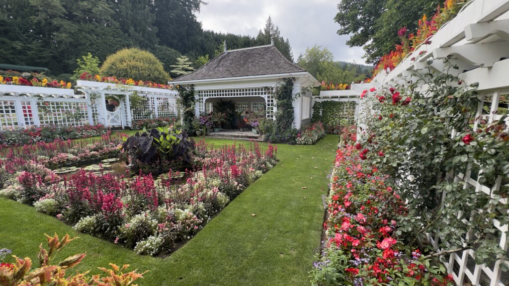 Formal flower garden with white trellis and colourful blooms at The Butchart Gardens in Victoria BC