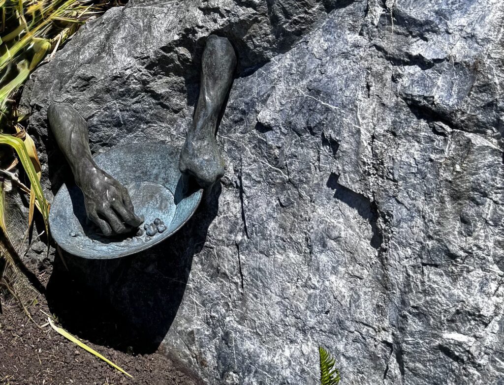 Bronze Hands of Time sculpture holding a gold pan, symbolizing Victoria's Gold Rush history.