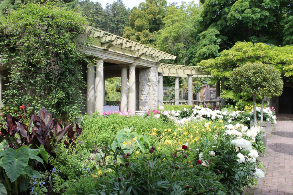 Colourful flowers surrounding a columned pergola in one of Hatley Castle’s many gardens.